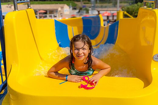 Lächelndes Mädchen auf Wasserrutsche im Camping CAPFUN La Pinède de Grimaud (83).