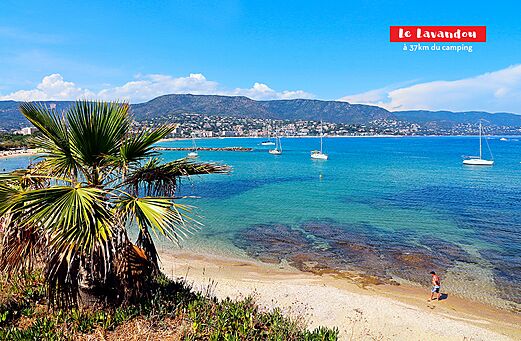 Sandstrand und türkisfarbenes Meer mit Segelbooten in Le Lavandou, Côte d'Azur.