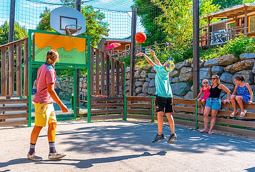 Basketballplatz mit Jugendlichen auf dem Campingplatz CAPFUN Plantas in SAINT VINCENT DE DURFORT (07).
