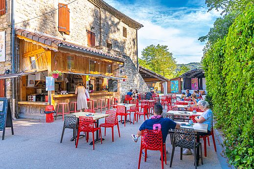 Außenbar und belebte Restaurantterrasse auf dem Campingplatz CAPFUN Plantas in SAINT VINCENT DE DURFORT (07).