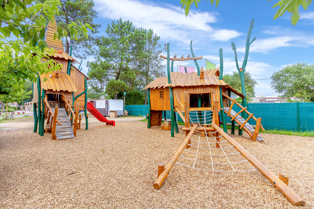 Wooden playground, slide, climbing net at CAPFUN Pomme de Pin Saubion (40).