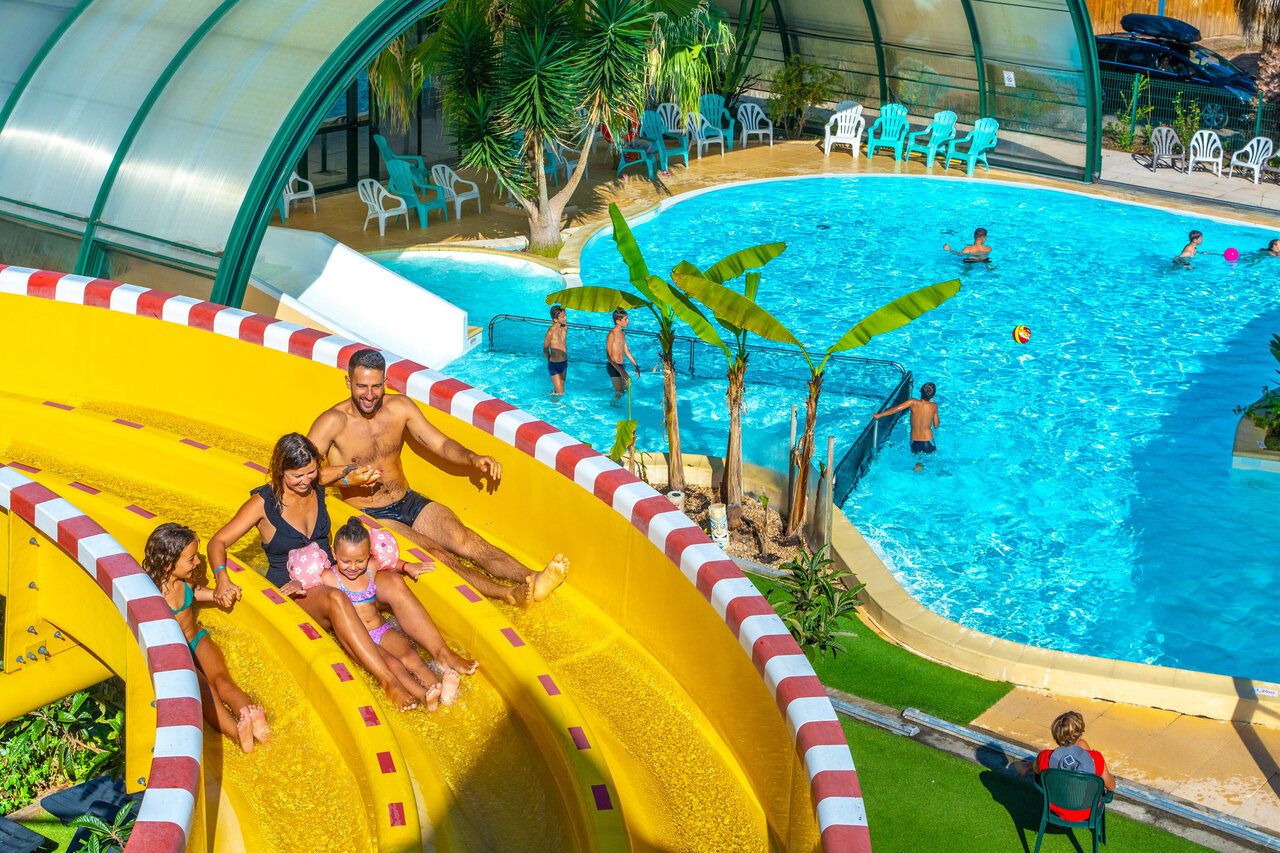 Family on water slide and pool at CAPFUN Pomme de Pin campsite in Saubion.