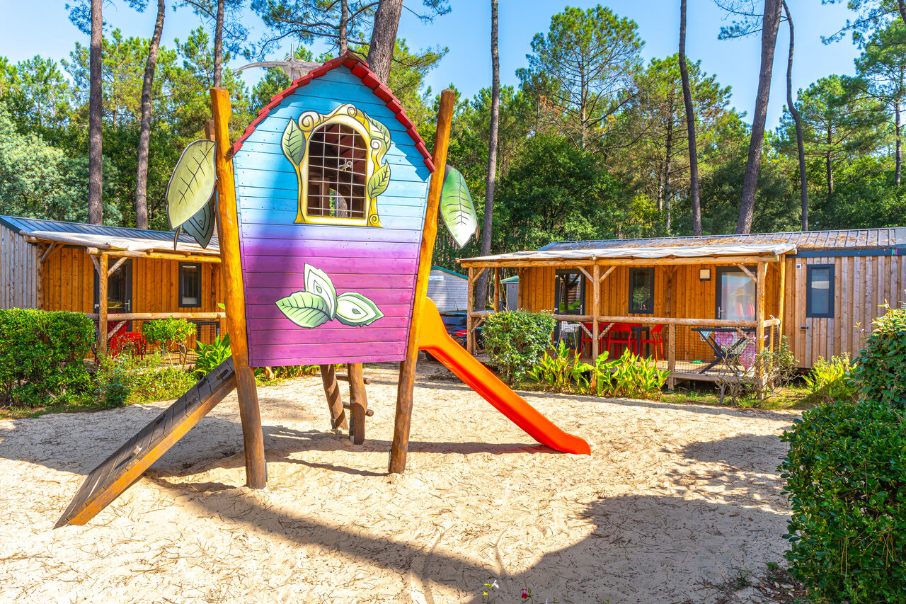 Colorful playground with slide and Mobile homes at CAPFUN Pomme de Pin campsite in Saubion (40).