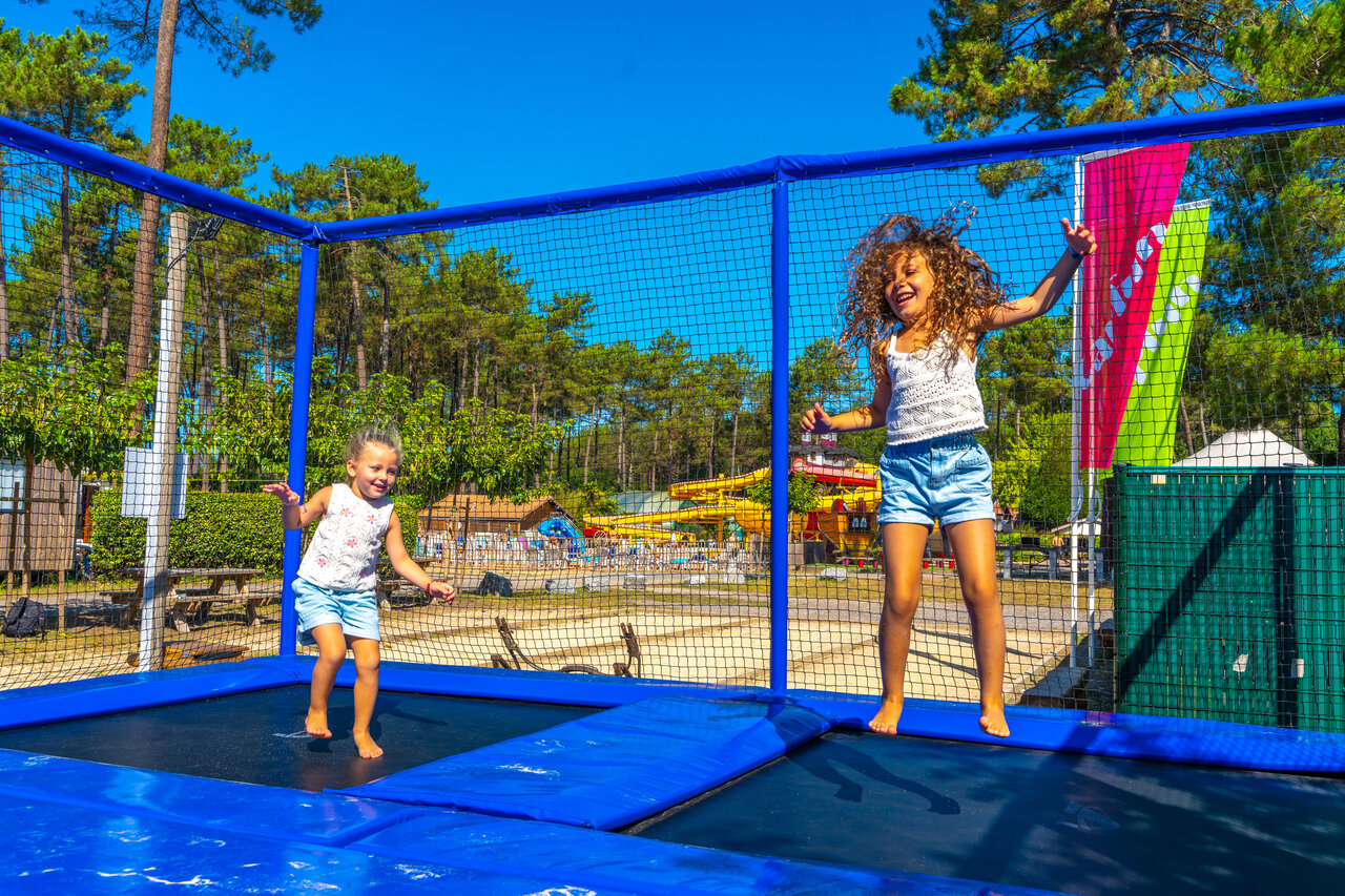 Children jumping on trampolines at CAPFUN Pomme de Pin campsite in Saubion (40).