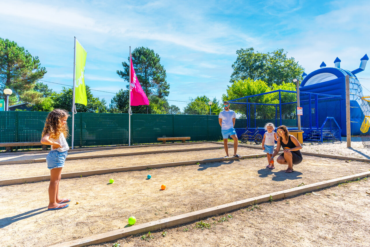 Family playing p�tanque on dedicated court at CAPFUN Pomme de Pin campsite in Saubion (40).