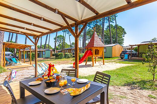 Spielhaus und Terrasse des Mobilheims auf dem Campingplatz CAPFUN Pomme de Pin in Saubion.