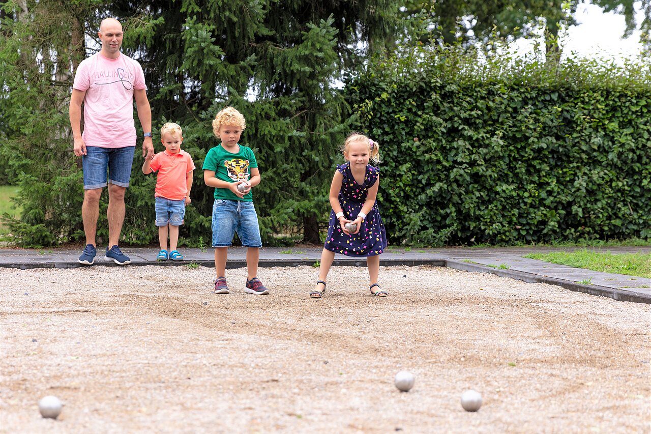 Familie spielt Boule auf Platz bei CAPFUN Ponderosa in Ulicoten.