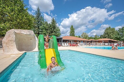 Wasserrutsche und Pool mit Kindern auf Campingplatz CAPFUN Les Portes du Beaujolais in Anse.