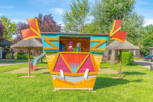 Bunte Spielstruktur mit Marionetten und Rutsche auf dem Campingplatz CAPFUN Les Portes du Beaujolais in Anse (69).