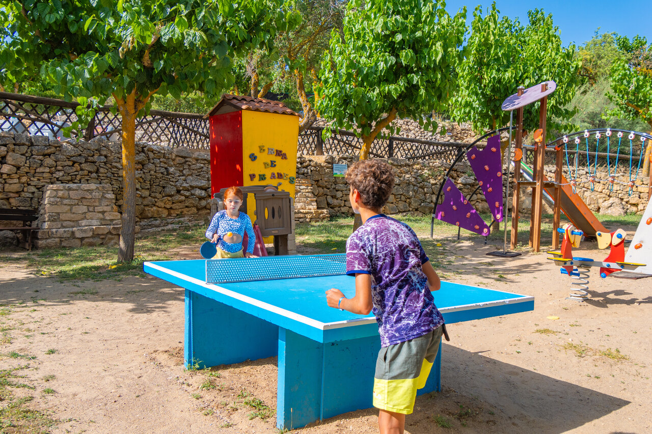 Kinder spielen Tischtennis auf einem Spielplatz auf dem Campingplatz CAPFUN Serra de Prades in Vilanova de Prades (43).