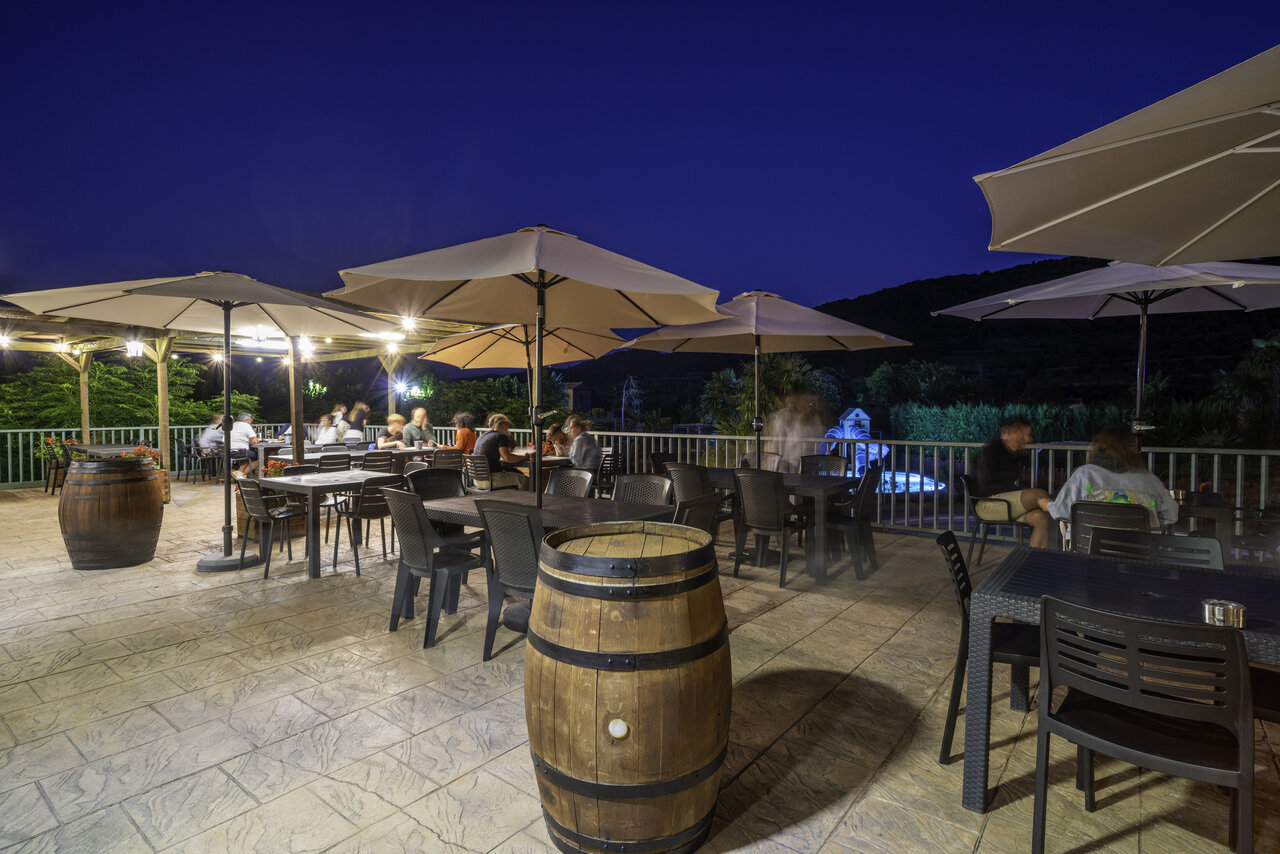Restaurantterrasse, Sonnenschirme, Pool auf dem Campingplatz CAPFUN Serra de Prades in Vilanova de Prades.