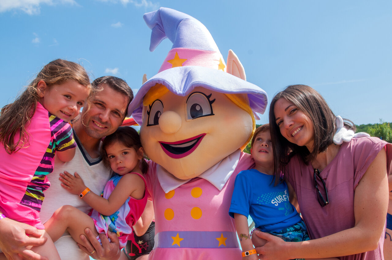 L�chelnde Familie posiert mit Camping-Maskottchen, Animation und Aktivit�ten f�r Kinder auf dem Campingplatz CAPFUN Serra de Prades in Vilanova de Prades (43).