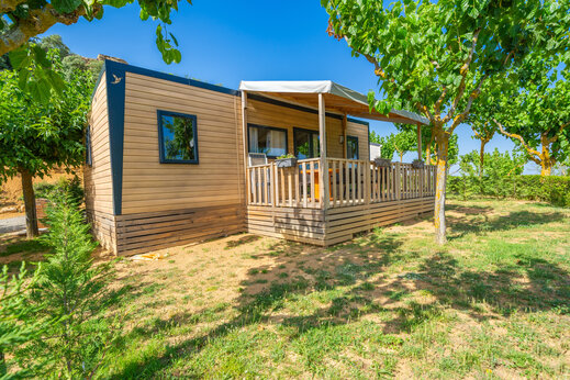 Modernes Mobilheim mit Holzterrasse auf dem Campingplatz CAPFUN Serra de Prades.