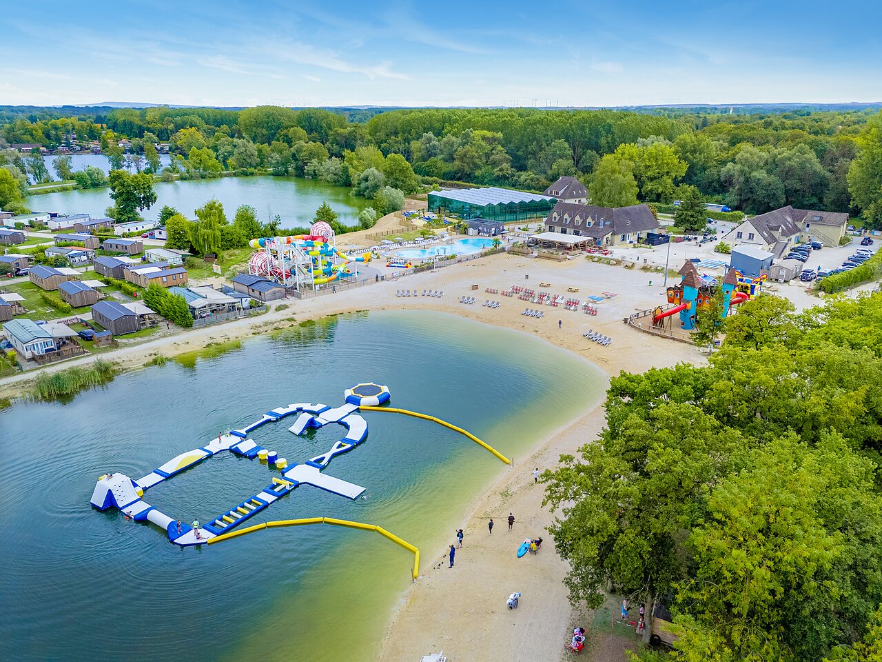 Aufblasbarer Wasserpark, Schwimmbad mit Rutschen und Mobilheime auf dem Campingplatz VAGUES OCEANES In der N�he des Brunnens in Gouaix (77).