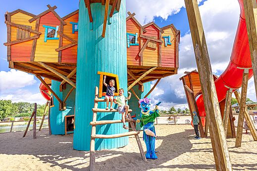 Kleurrijke speeltuin met glijbanen en kinderen op camping VAGUES OCEANES.