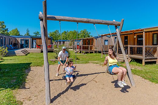 Spelen, blije familie op de schommels op camping VAGUES OCEANES Pr�s de la Fontaine � Gouaix (77).