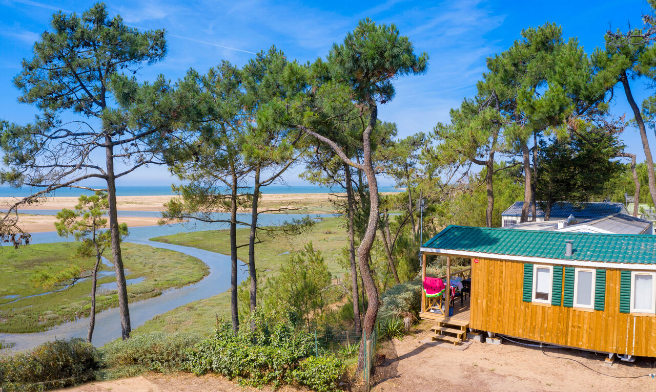 Holz-Mobil-home mit Blick auf Fluss, Strand und Meer auf dem Campingplatz CAPFUN Prises in La TRANCHE SUR MER (85).