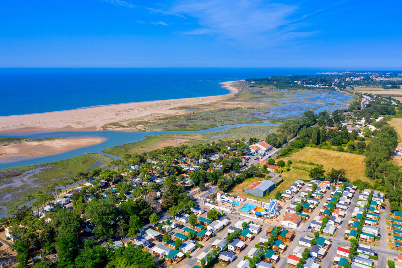 Camping CAPFUN Prises (85): Luftaufnahme, Mobilheime, Pool, Rutschen, Strand.