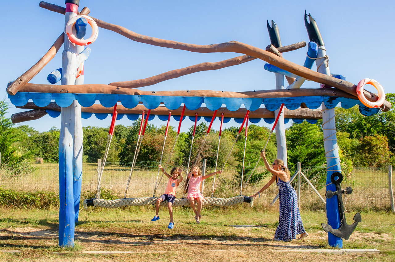 Grote bootvormige schommel met kinderen op camping CAPFUN Quatre Vents d'Ol�ron.