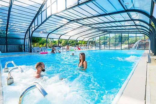 Überdachtes Schwimmbad, Whirlpool und Badegäste auf dem Campingplatz CAPFUN Quatre Vents d'Oléron in St Georges d'Oléron (17).