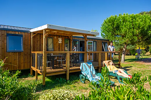 Mobil-home en bois avec terrasse couverte et chaises au camping CAPFUN Quatre Vents d'Oléron à St Georges d'Oléron (17). Mobil-home en bois avec terrasse couverte et chaises au camping CAPFUN Quatre Vents d'Oléron à St Georges d'Oléron (17).