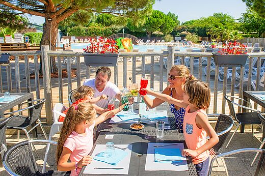 Famille trinquant au restaurant extérieur du camping CAPFUN Quatre Vents d'Oléron.
