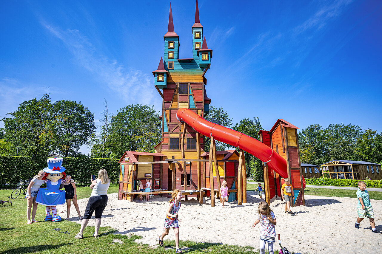 Buntes Spielschloss mit Rutsche und Kindern auf dem Campingplatz CAPFUN Rakelbos in Westelbeers.