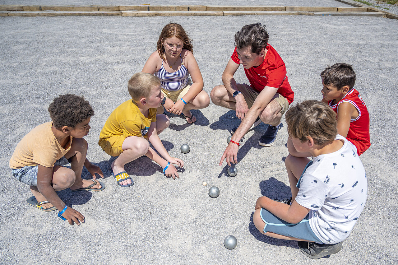 Kinder und Animateur spielen Boule auf CAPFUN Rakelbos in Westelbeers.