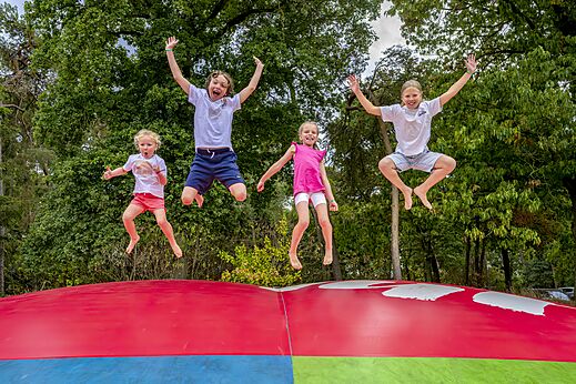Kinder springen auf einem riesigen H�pfkissen auf dem Campingplatz CAPFUN Rakelbos in Westelbeers.