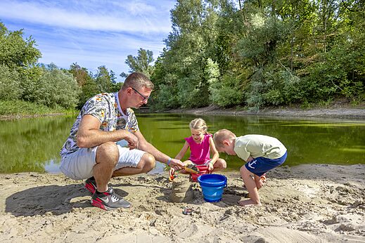 Familie spielt im Sand am Wasser auf CAPFUN Rakelbos, Westelbeers.