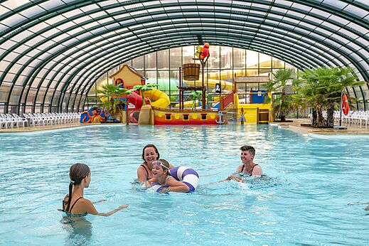�berdachtes Schwimmbad, Wasserspiele, Familie auf Campingplatz CAPFUN Rakelbos in Westelbeers.