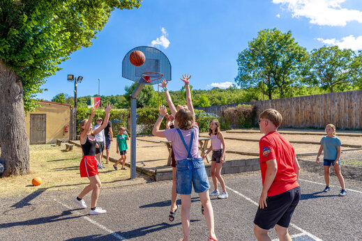 Terrain de basketball avec enfants jouant au camping CAPFUN Ranch des Volcans à Chatel-Guyon (63).