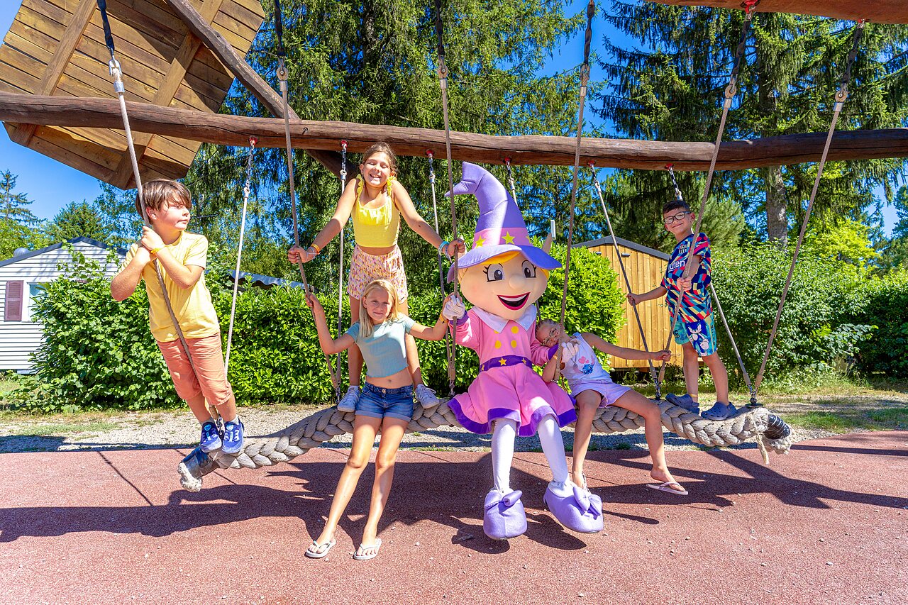 Children and mascot on giant rope swing at CAPFUN R�gni�re campsite in VILLETTE D'ANTHON (38).