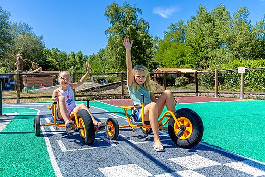 Kinder auf Tret-Gokarts auf dem Campingplatz CAPFUN Régnière VILLETTE D'ANTHON.