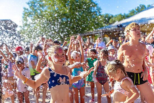 Fröhliche Kinder bei einem Schaumparty-Event auf dem Campingplatz CAPFUN Régnière in VILLETTE D'ANTHON (38).