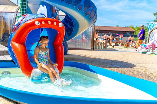 Bunte Wasserrutsche, Kind spielt auf Campingplatz CAPFUN Régnière in VILLETTE D'ANTHON (38).