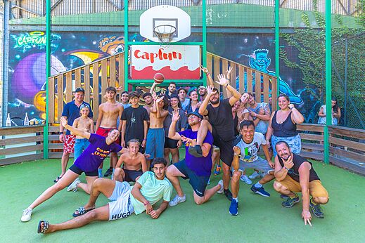 Gruppe Urlauber und Animateure posieren auf einem Capfun Multisportplatz