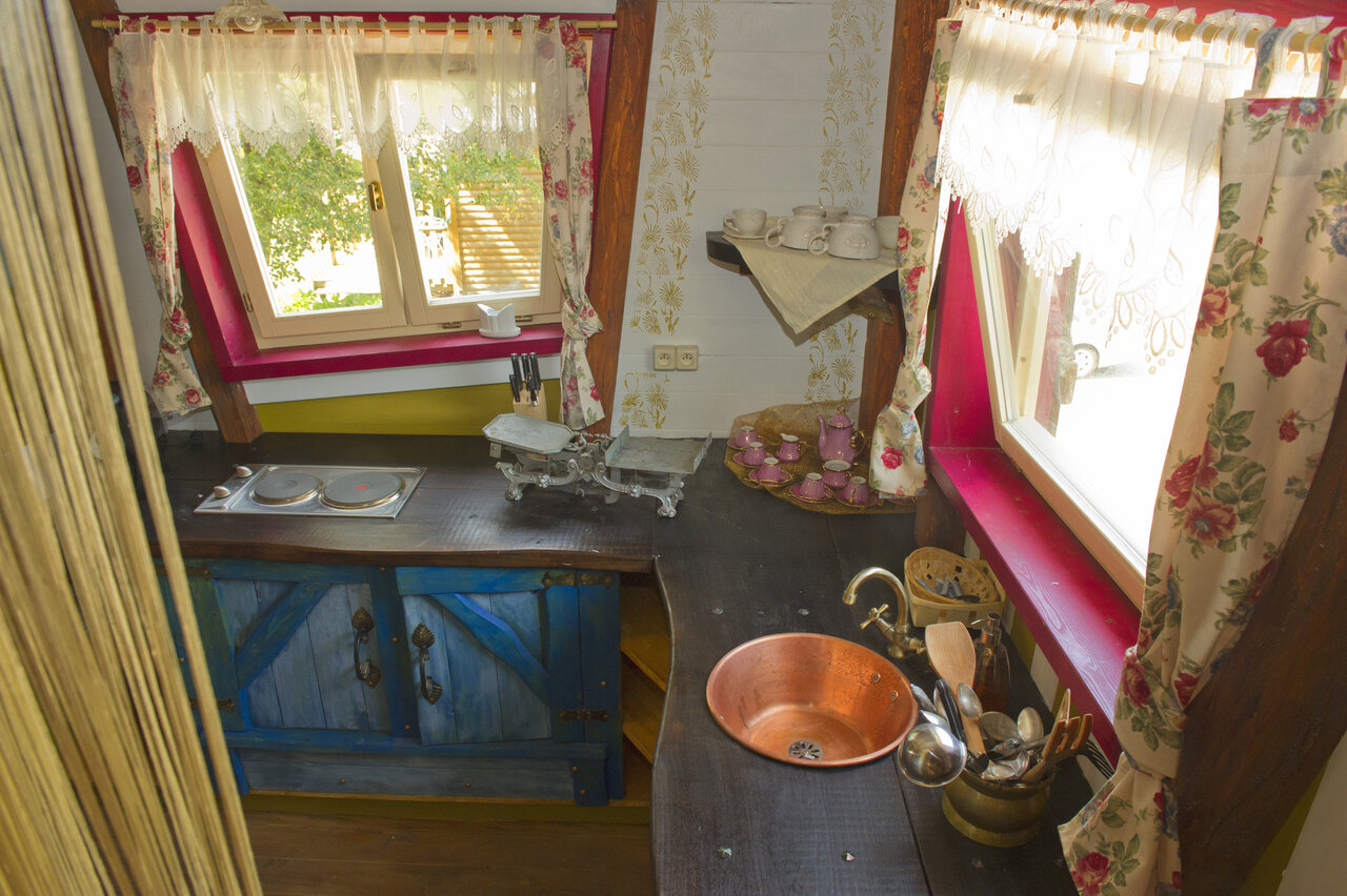 Rustikale ausgestattete K�che mit Kupferwaschbecken auf dem Campingplatz CAPFUN R�gni�re: Baumh�user in Lyon in Villette d'Anthon (38).