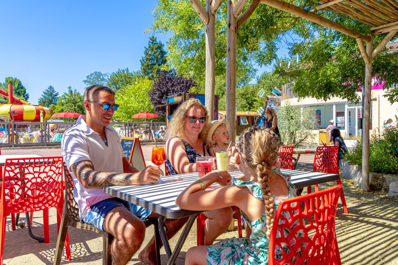 Familie auf Terrasse, Pool, Wasserrutsche auf dem Campingplatz CAPFUN R�gni�re: Baumh�user in Lyon in Villette d'Anthon (38).