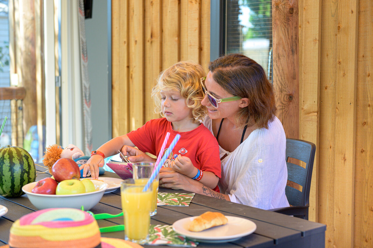 Familienessen auf Mobilheim-Terrasse auf dem Campingplatz CAPFUN R�gni�re in Villette d'Anthon.