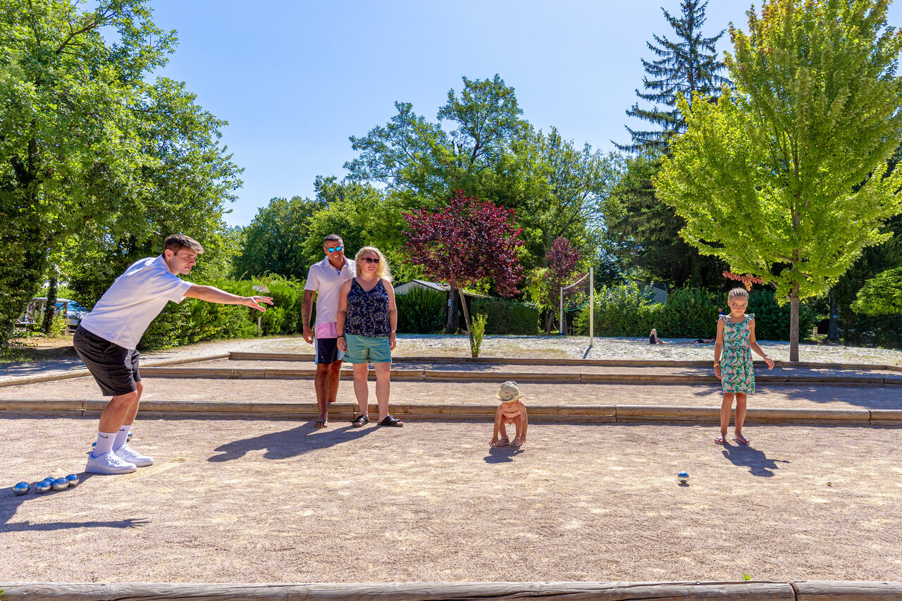 Familie spielt Boule auf Platz auf Camping CAPFUN R�gni�re in Villette d'Anthon.