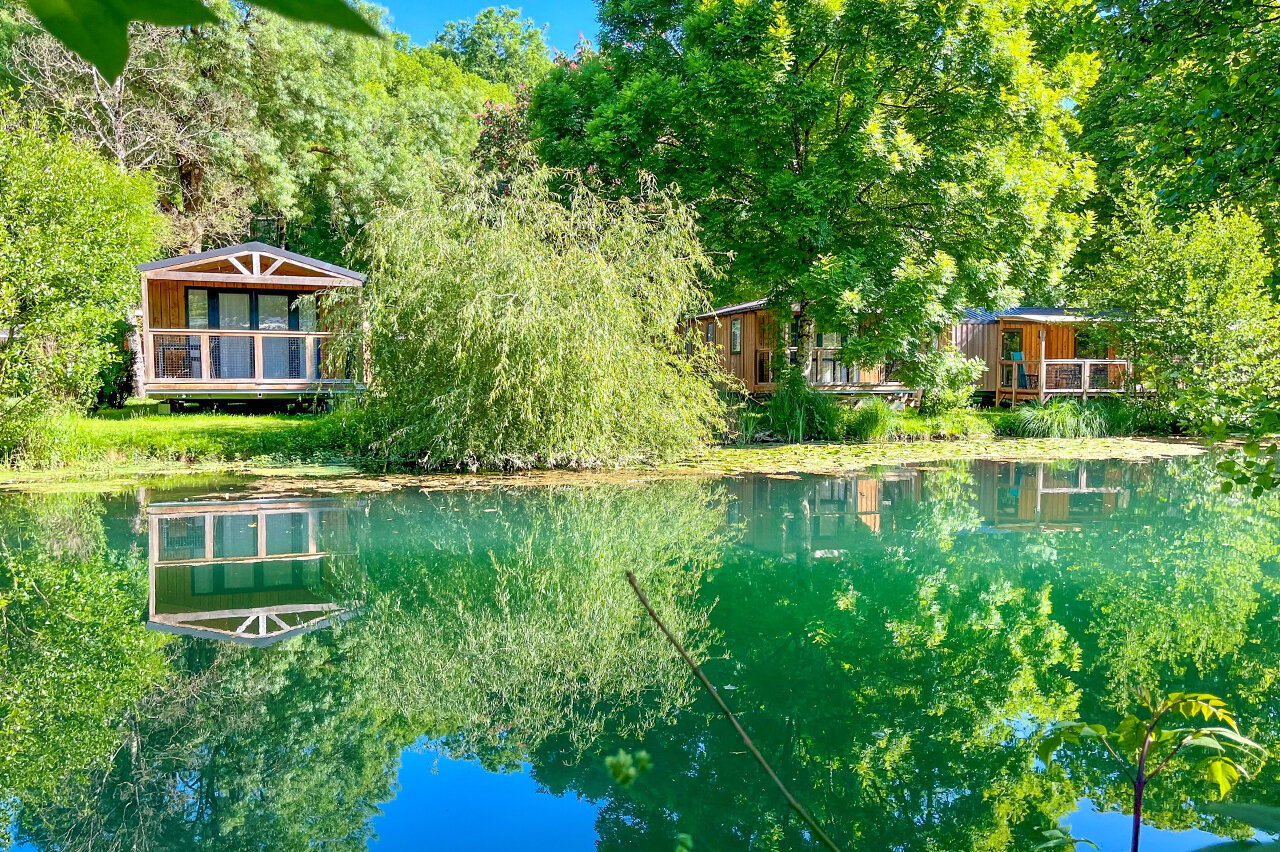Wooden Mobil-homes by a pond, nature at CAPFUN La Rivi�re campsite in Valence-en-Poitou (86).