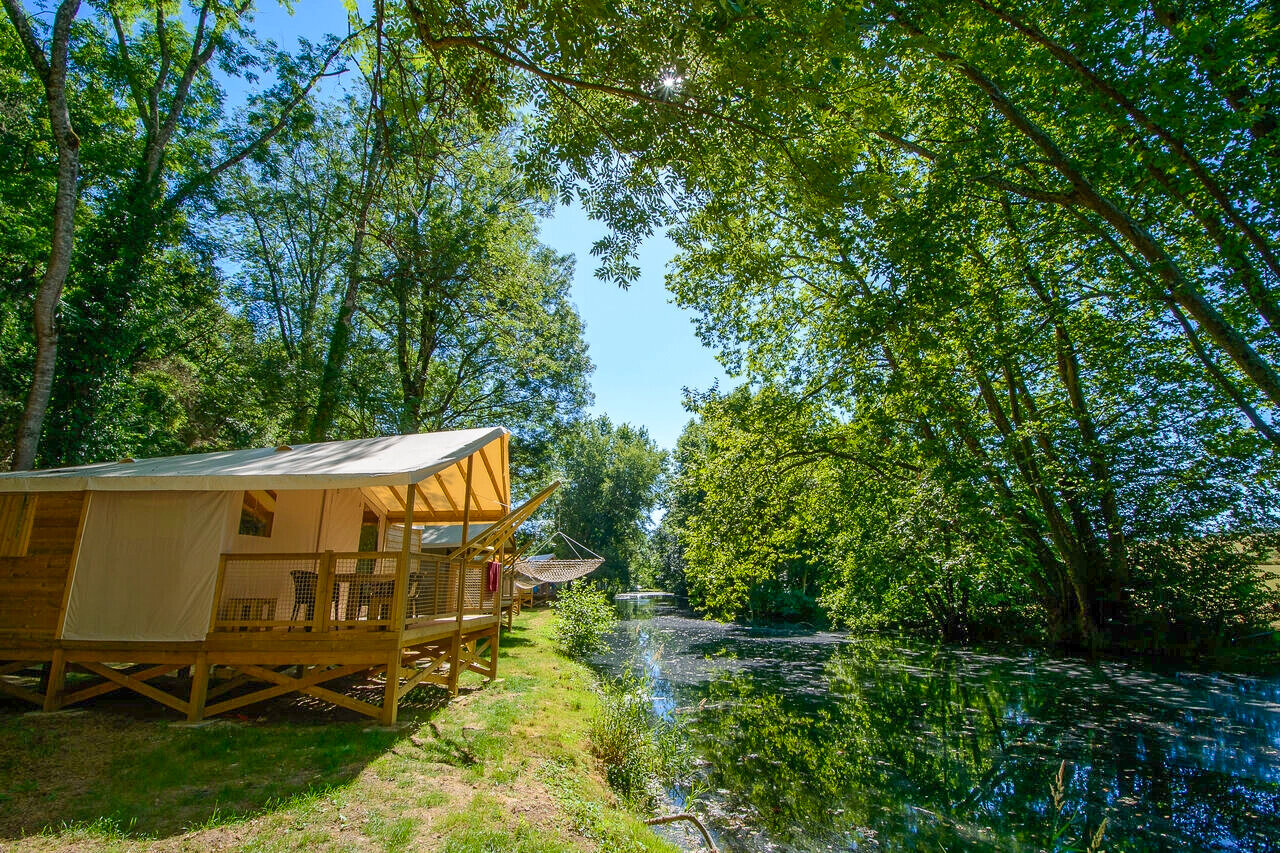 Comfortable lodge tent by the river at CAPFUN La Rivi�re campsite in Valence-en-Poitou (86).