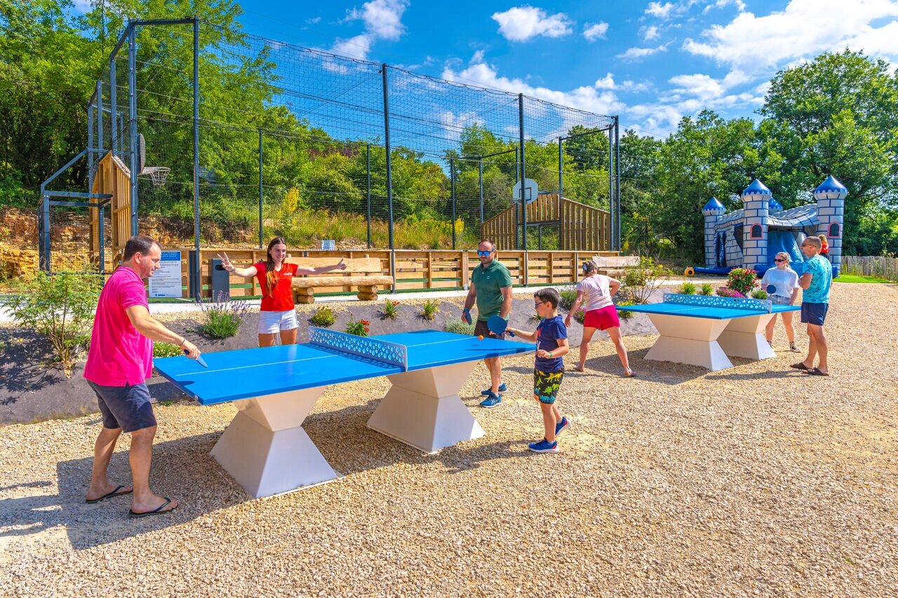 Families playing table tennis, multisport court, inflatable castle at CAPFUN La Rivi�re campsite in Valence-en-Poitou (86).