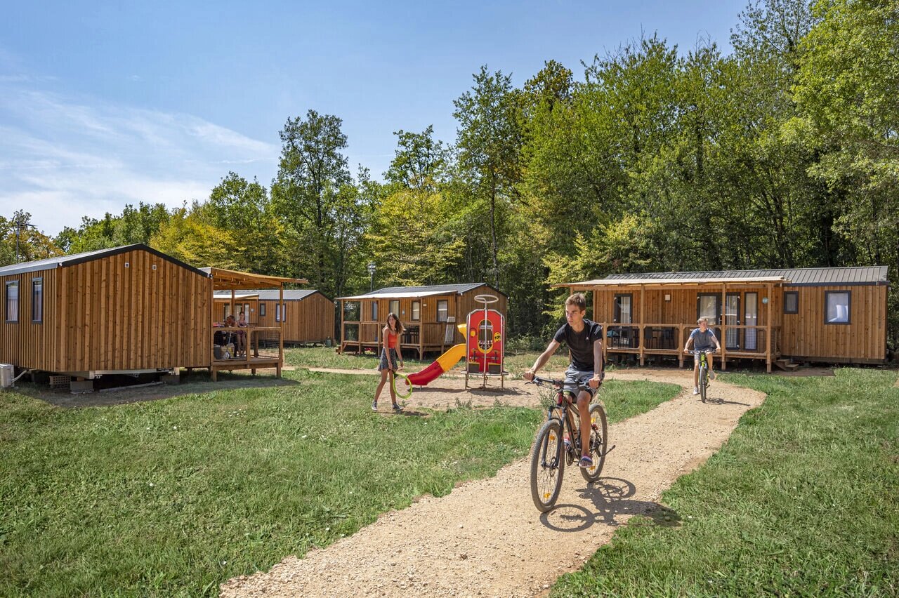Mobile homes, playground, children cycling at CAPFUN La Rivi�re campsite in Valence-en-Poitou.