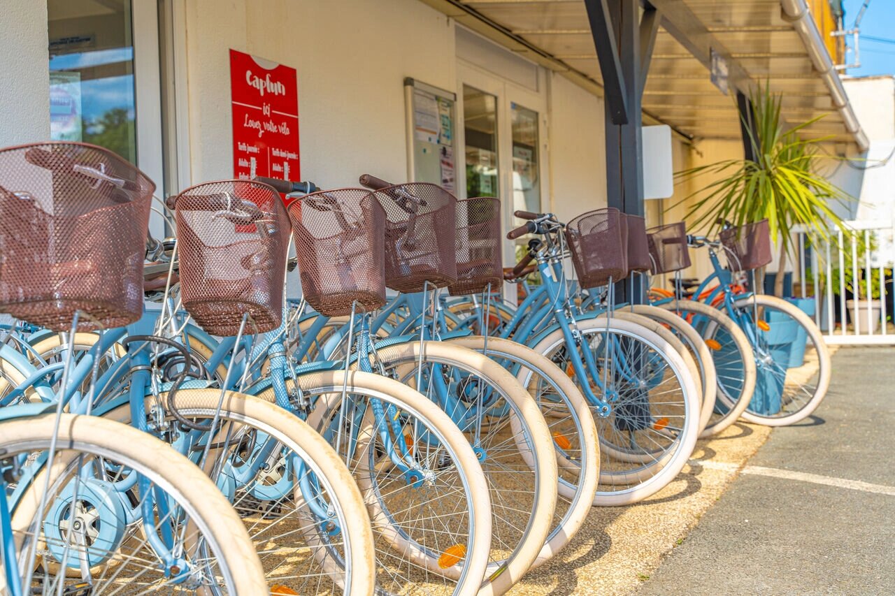 Blue rental bicycles with baskets at CAPFUN La Rivi�re campsite, Valence-en-Poitou (86).