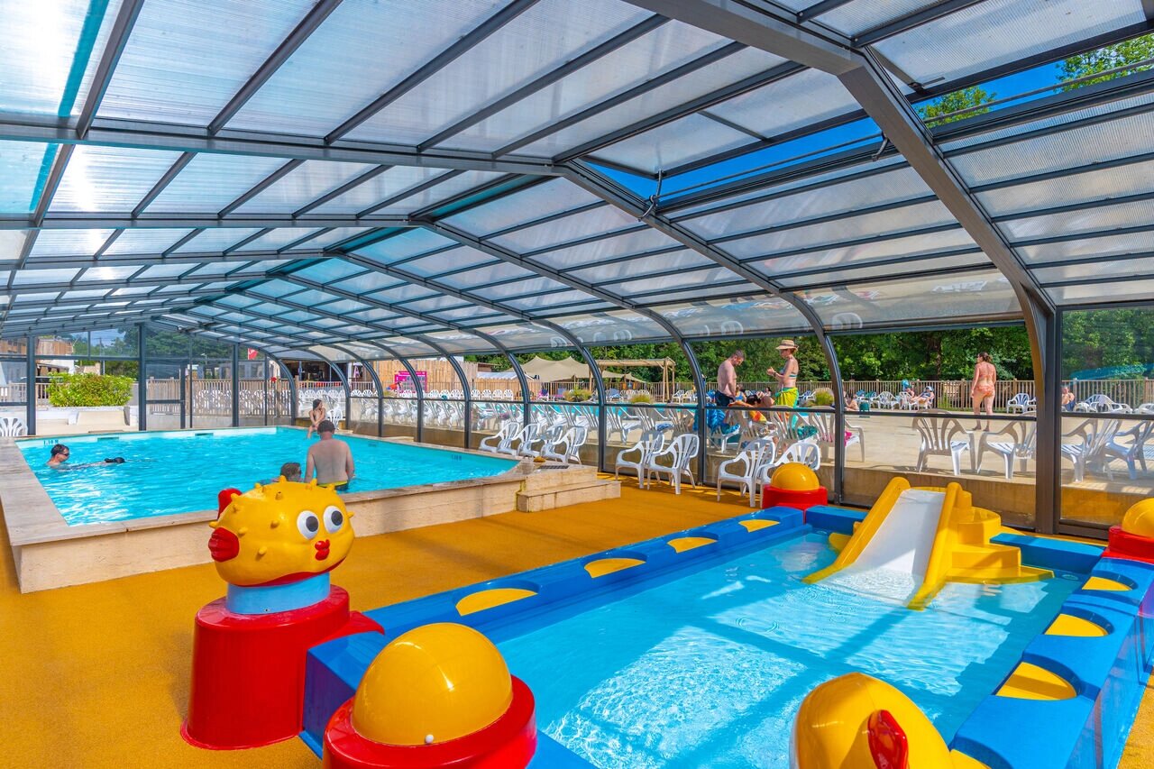 Covered swimming pool with slide and children's paddling pool at CAPFUN La Rivi�re campsite in Valence-en-Poitou (86).