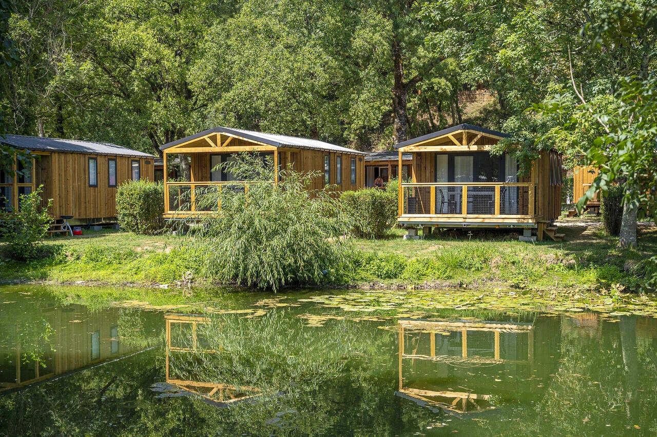 Wooden mobile homes with terrace, pond, at CAPFUN La Rivi�re in Valence-en-Poitou.