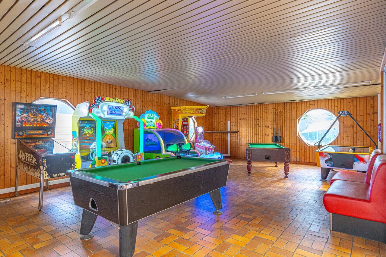 Game room with pool tables, pinball, and arcade games at CAPFUN La Rivi�re campsite in Valence-en-Poitou (86).