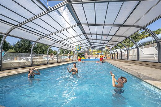 Überdachtes Schwimmbad mit Kindern, Rutschen, auf Campingplatz CAPFUN La Rivière in Valence-en-Poitou (86).